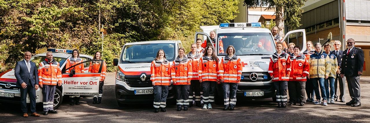 Bereitschaft in Einsatzkleidung verteilt zwischen drei Einsatzfahrzeugen des Ortsvereins